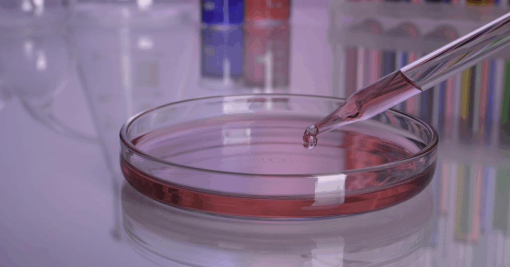 lab EMR integration concept – pipette dropping sample into a petri dish in a clinical lab, symbolizing automated orders and results exchange