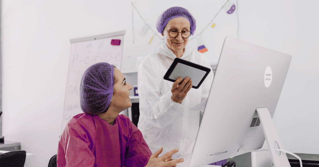 Clinician and lab tech collaborate at a desktop and tablet, reviewing results — workflow-first healthcare API development for daily workflows.