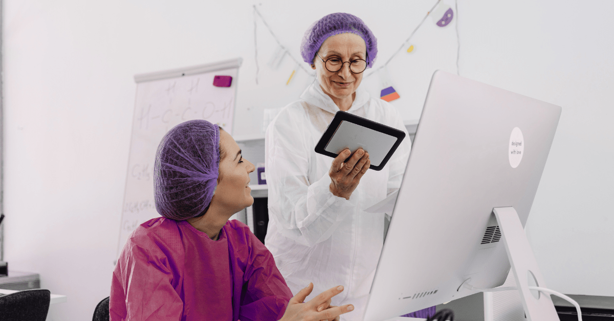 Clinician and lab tech collaborate at a desktop and tablet, reviewing results — workflow-first healthcare API development for daily workflows.